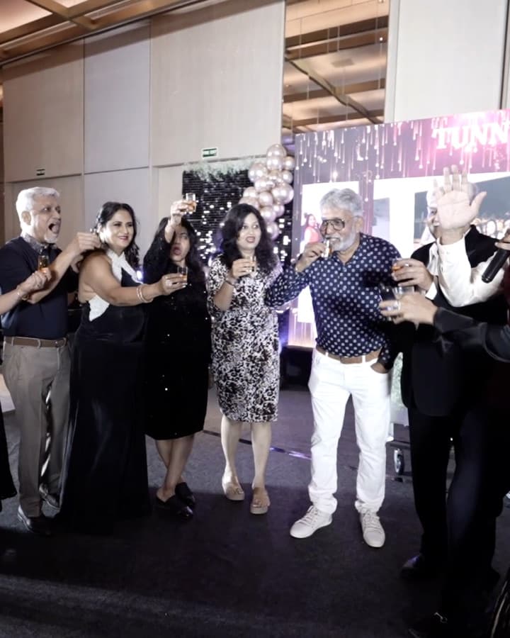 Guests standing together raising their glasses, one with a hand in the air